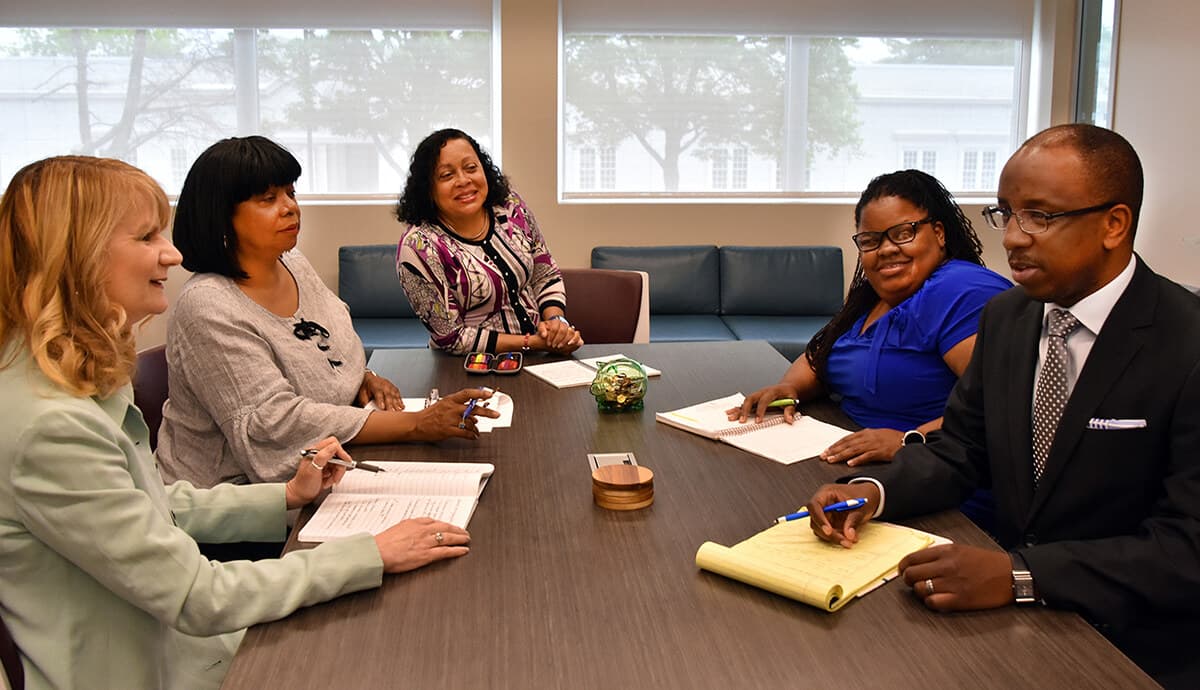 The ABEC staff seated around a conference table reviewing loan documentation