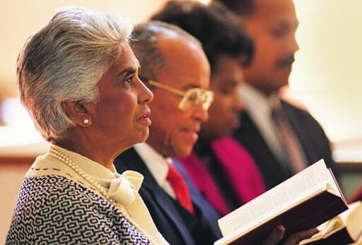 Members of a congregation following along in their hymnals during worship