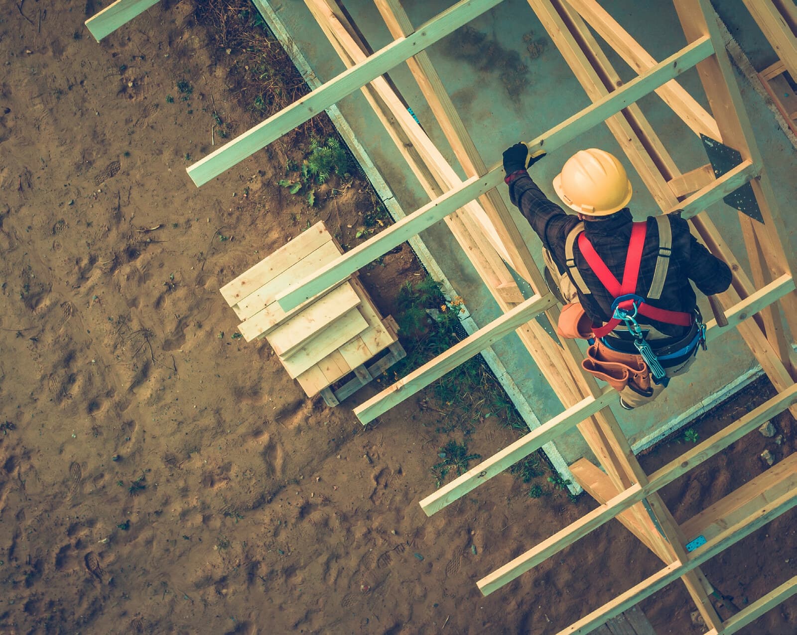 Overhead view of a framer walking the joists of a new building under construction